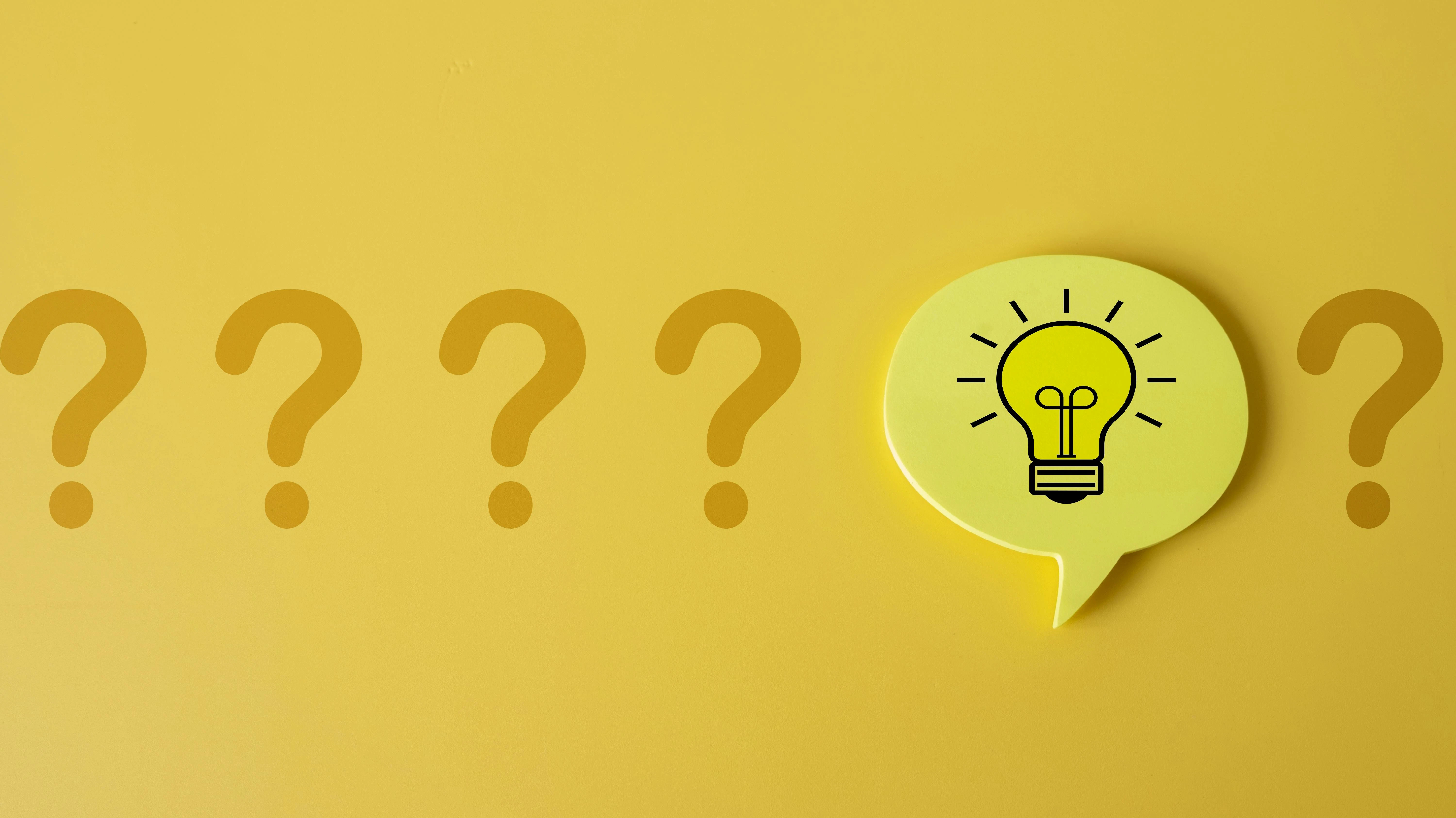 Row of five question marks with an idea lightbulb speech bubble placed before the fifth question mark.