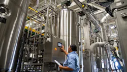 Worker examines control panel at Locus Fermentation Solutions Worker examines control panel at Locus Fermentation Solutions