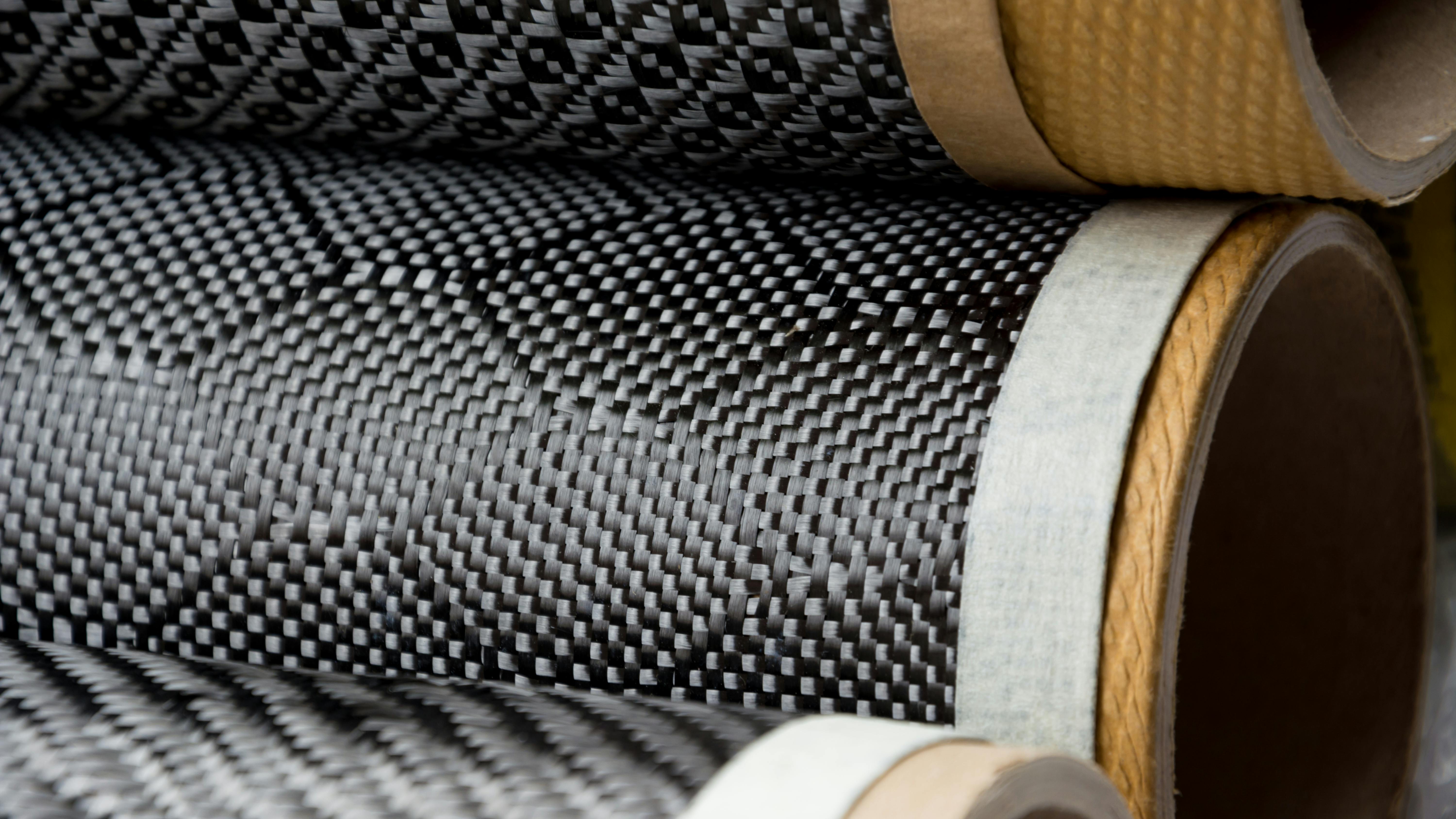 Black carbon fiber composite raw material close up background