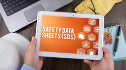 Worker holds tablet with Safety Data Sheets (SDS) displayed on screen