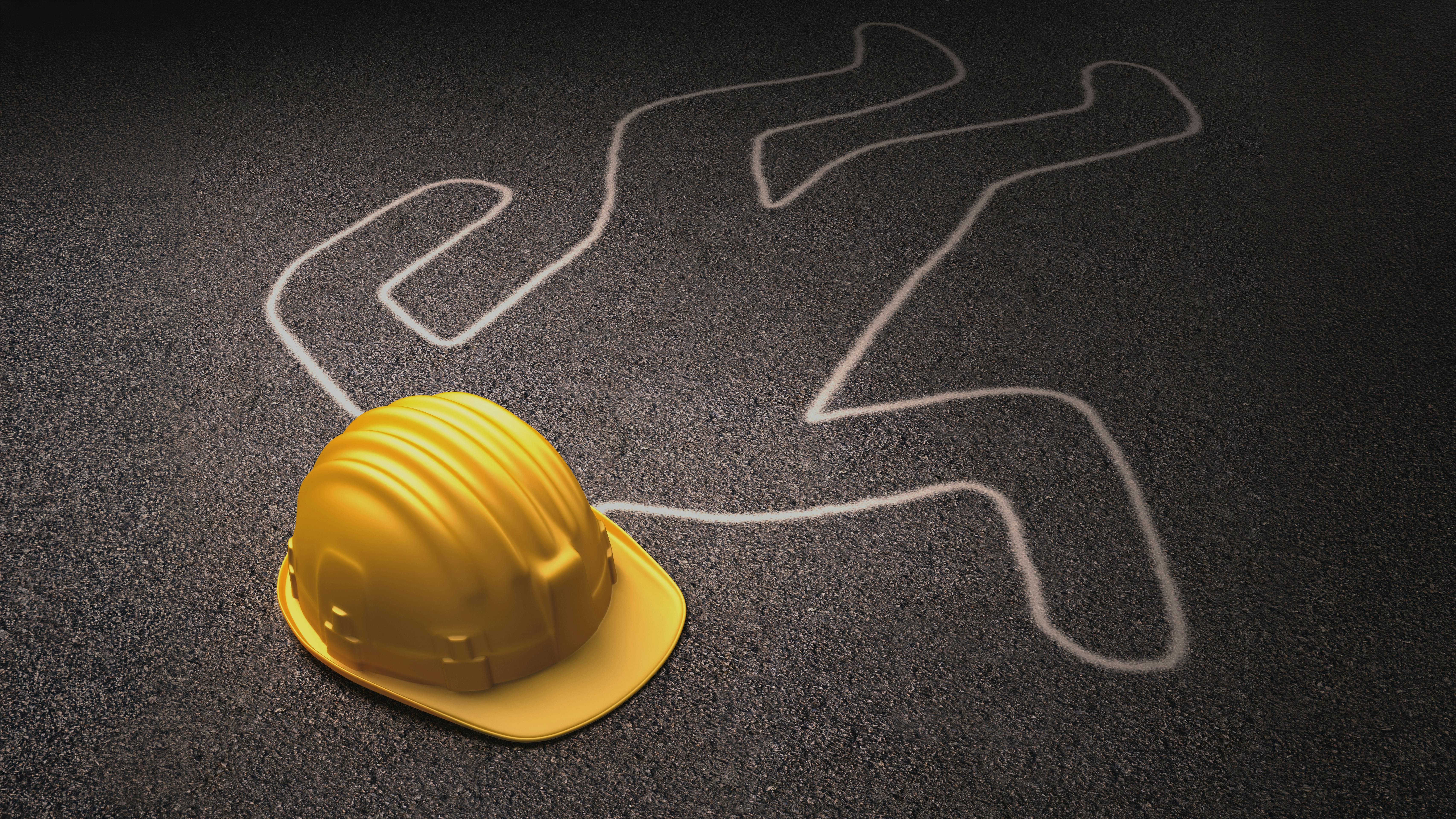 chalk body outline and hard hat on asphalt