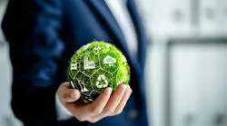 Businessman holding green ball made of grass, surrounded by environment icons.