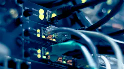 Close-up of network switch ports with ethernet cables and glowing yellow status indicator lights. Close-up of network switch ports with ethernet cables and glowing yellow status indicator lights.
