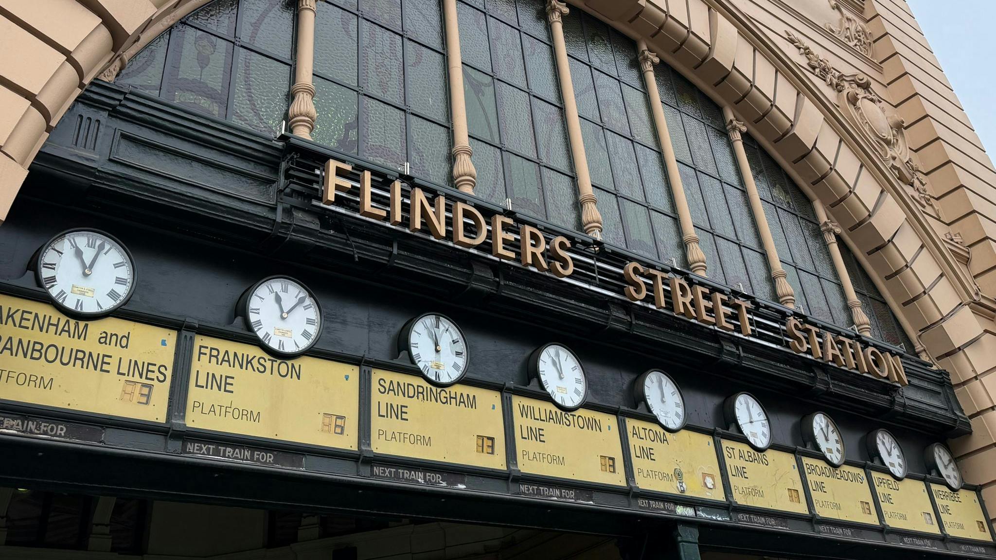 A line of clocks along a wall at Flinders Street Station in Melbourne, Australia