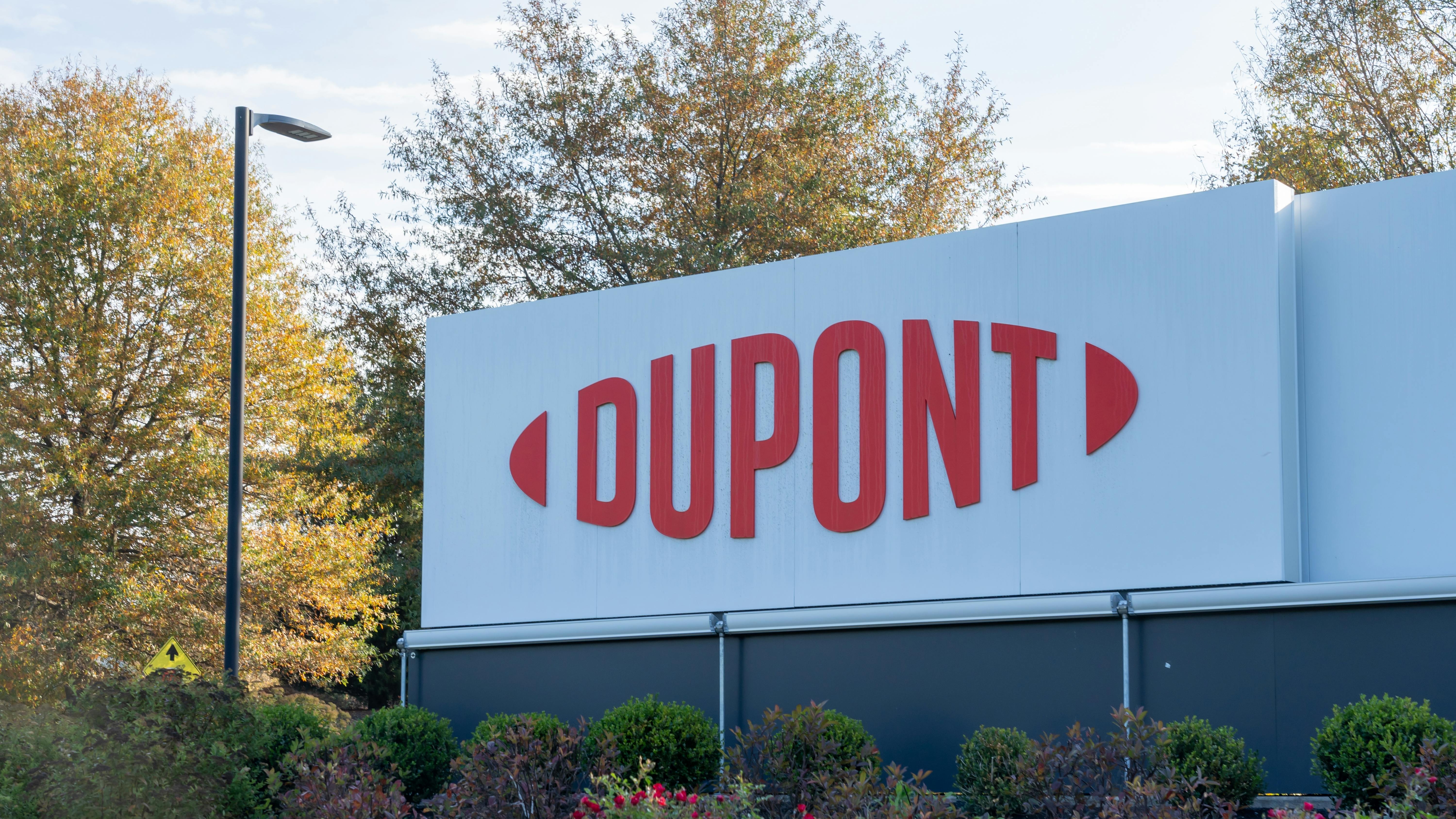 DuPont sign displayed at headquarters with bushes and trees in the background.