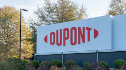 DuPont sign displayed at headquarters with bushes and trees in the background.
