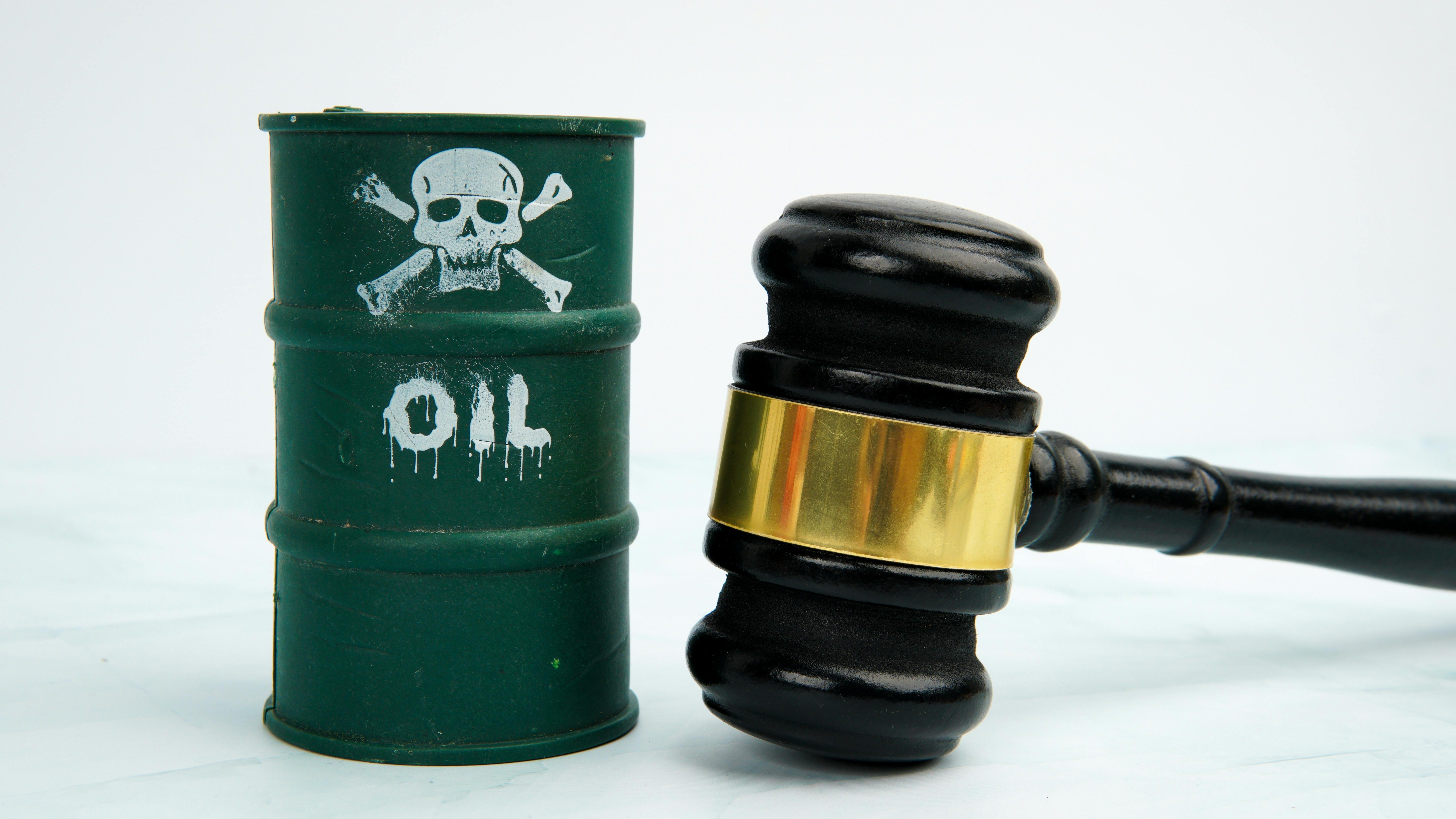Judge's gavel next to an oil barrel