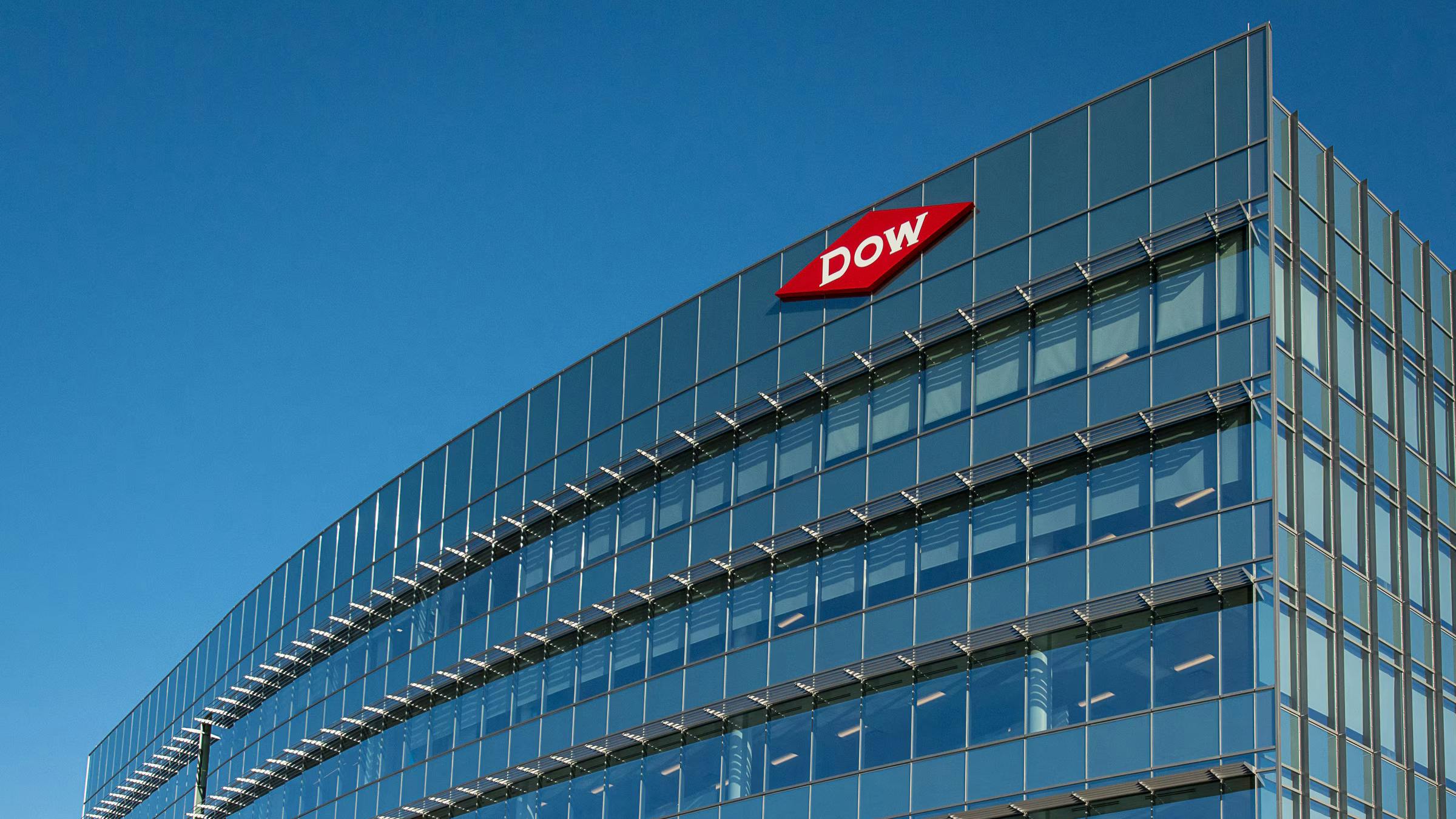 exterior building shot of Midland, Michigan headquarters of Dow Corp with logo on building against bright blue sky