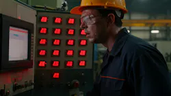 A factory worker in a hard hat and safety glasses monitors a control panel with red LED displays. A factory worker in a hard hat and safety glasses monitors a control panel with red LED displays.