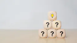 Wooden blocks stacked in a pyramid with question marks, topped by a block with a lightbulb icon Wooden blocks stacked in a pyramid with question marks, topped by a block with a lightbulb icon