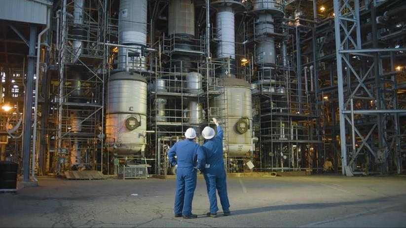 Two workers stand in front of Chemours Washington Works chemical facility