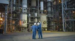 Two workers stand in front of Chemours Washington Works chemical facility