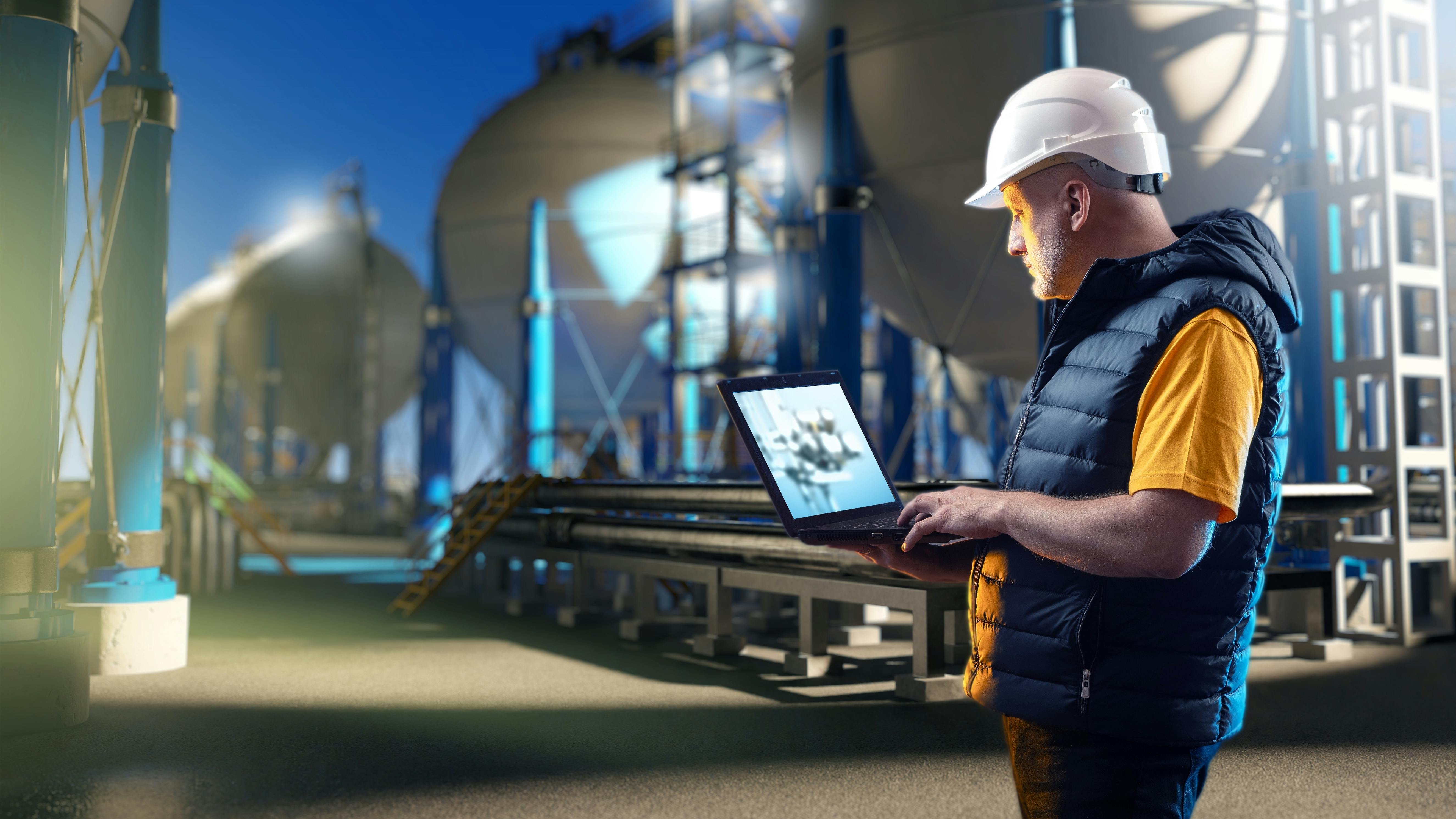 Engineering specialist near gas storage with spherical tanks for storing liquefied gas in the background at night