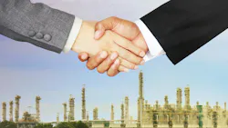 close up of two business men shaking hands with chemical plant in the background