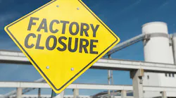 Factory Closure sign with plant tower and conveyor in background