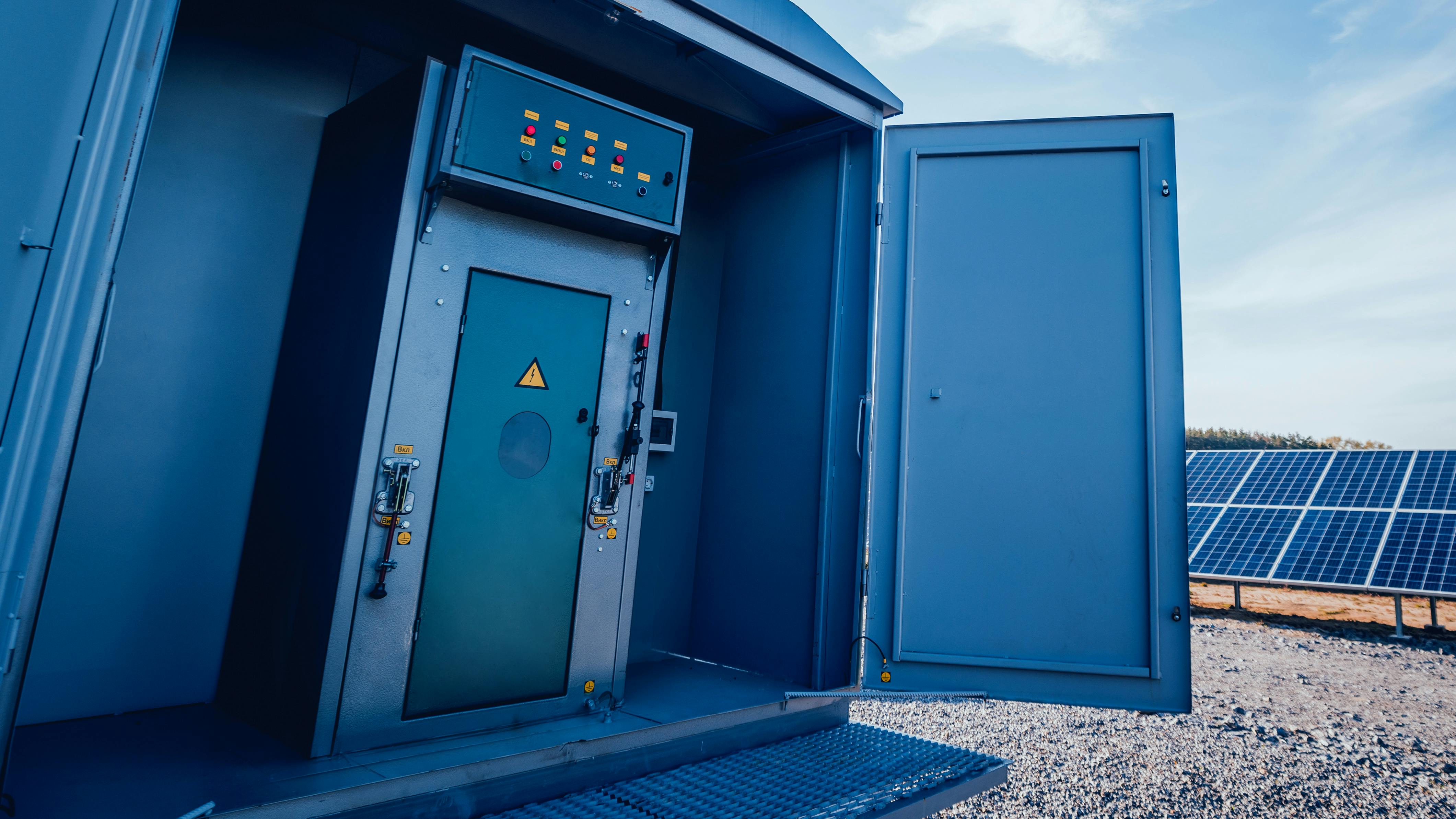 power grid control cabinet with solar panels in background