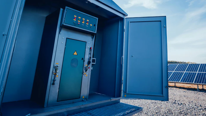power grid control cabinet with solar panels in background