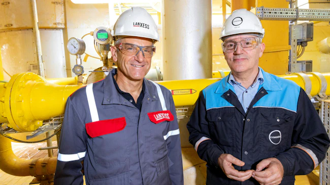 Michael Ertl, Head of LANXESS' Inorganic Pigments business unit, and Rob Eek, Production Manager at Covestro in Krefeld-Uerdingen, stand in front of the new hydrogen pipeline serving LANXESS' iron oxide plant.