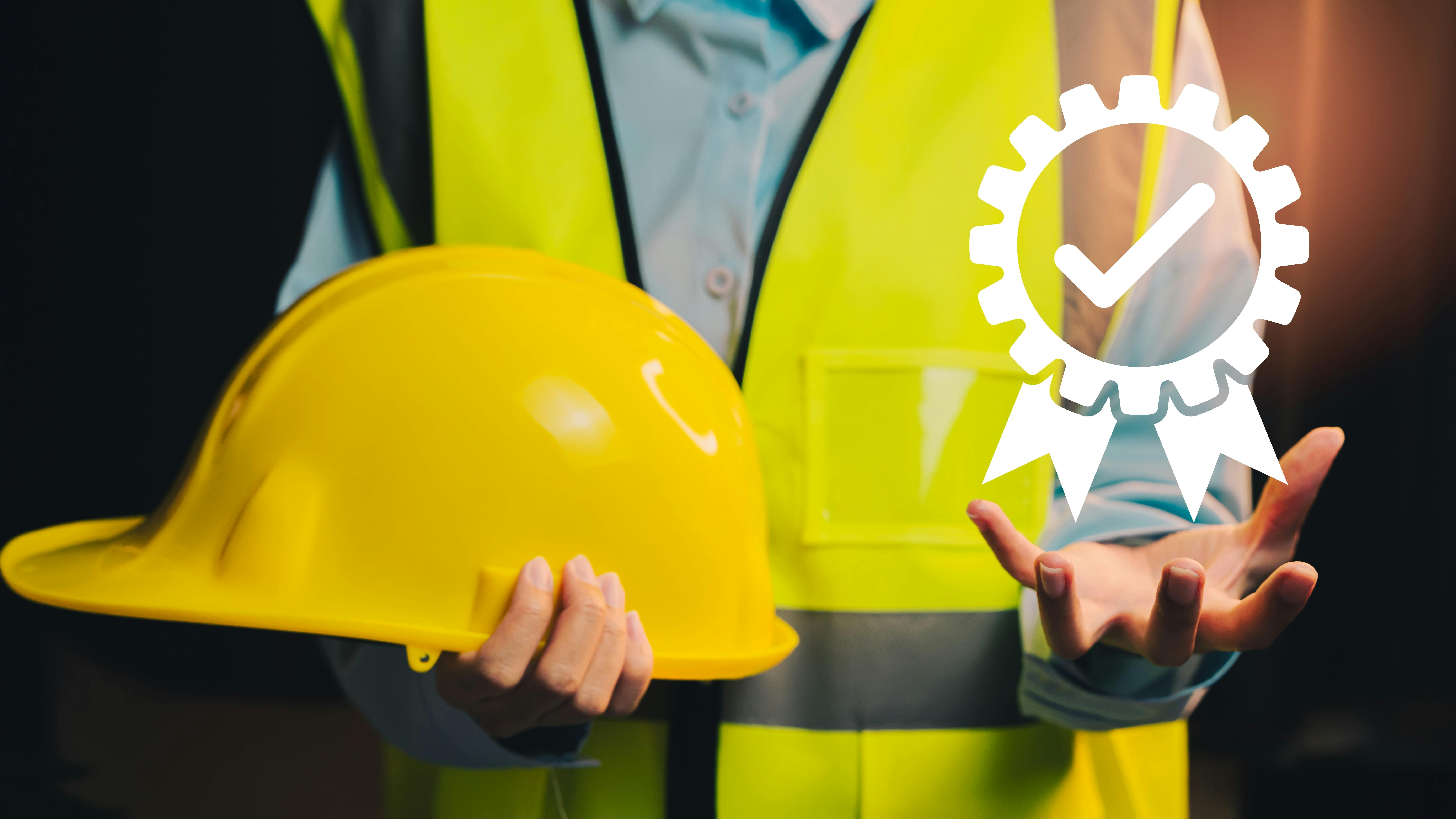 engineer in safety vest holds hard hat in one hand with digital icon of a safety certification ribbon in palm of other hand
