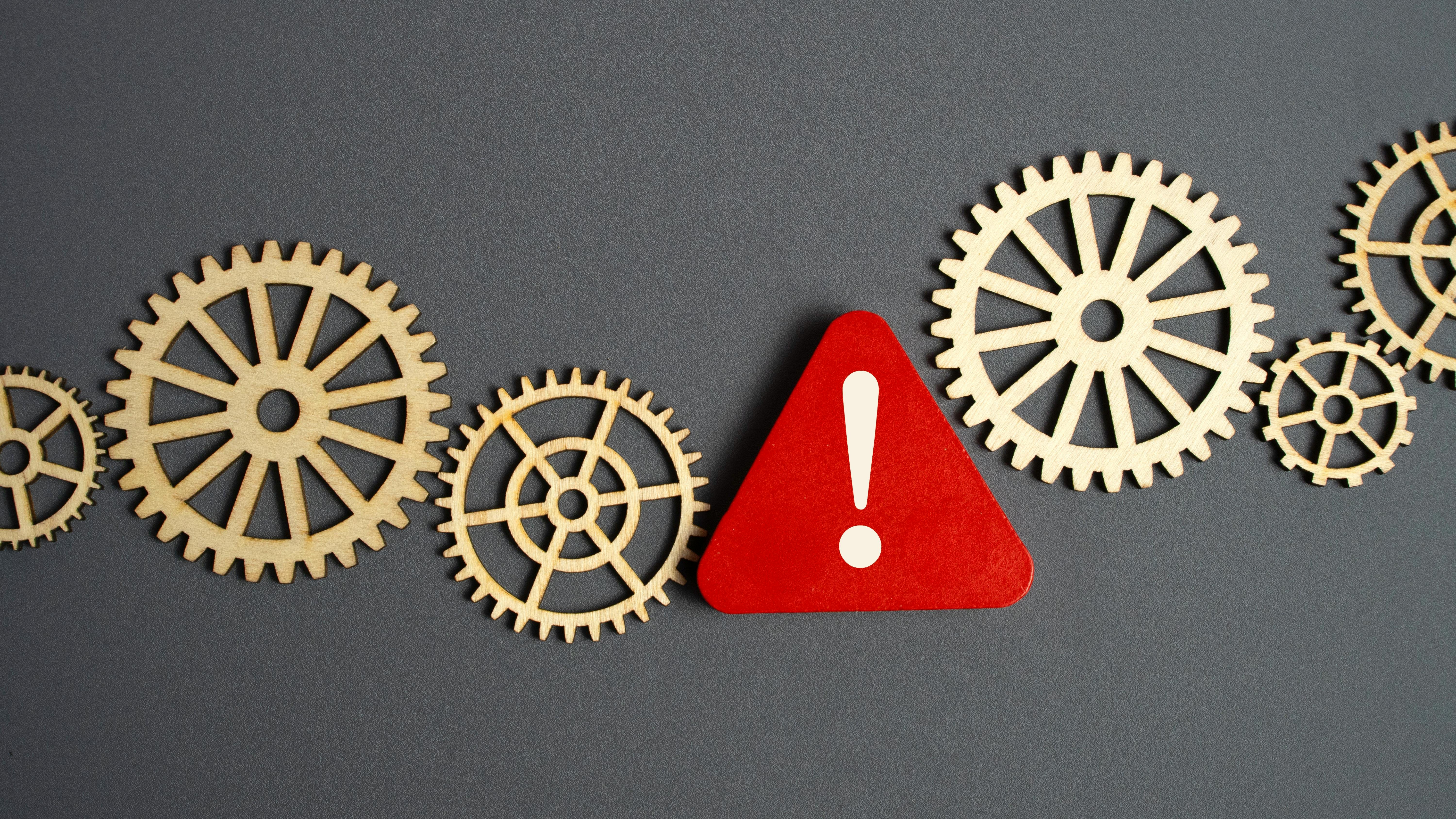 Gears with a caution sign between them