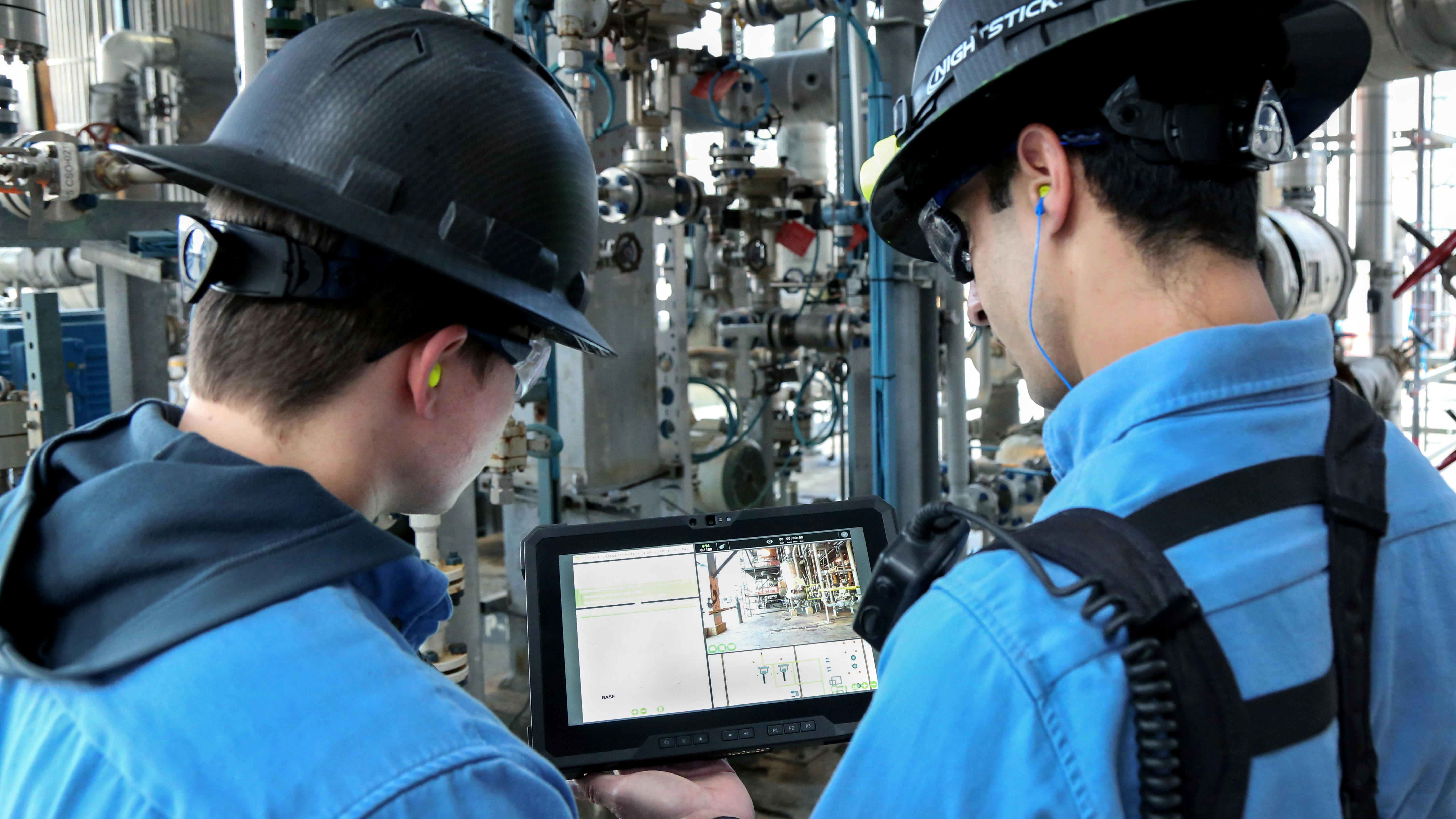 Young workers review tablet with digital similation of plant