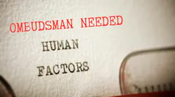 Paper in typewritter with words Humans Factors, and above it in red, Ombudsman Needed