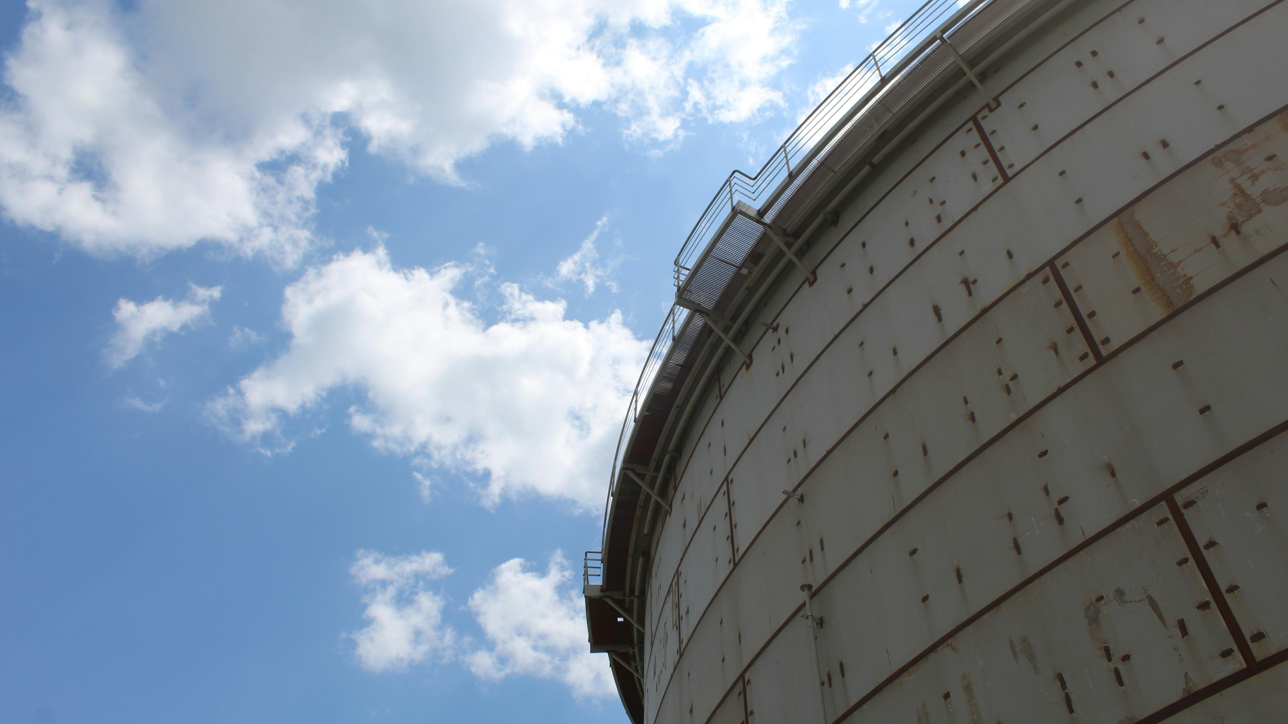 Corrosion on tank agains blue sky and clouds