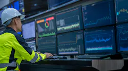 Engineer working in front of display screens in control room
