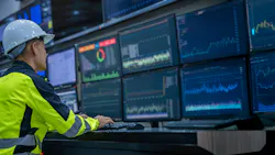 Engineer working in front of display screens in control room