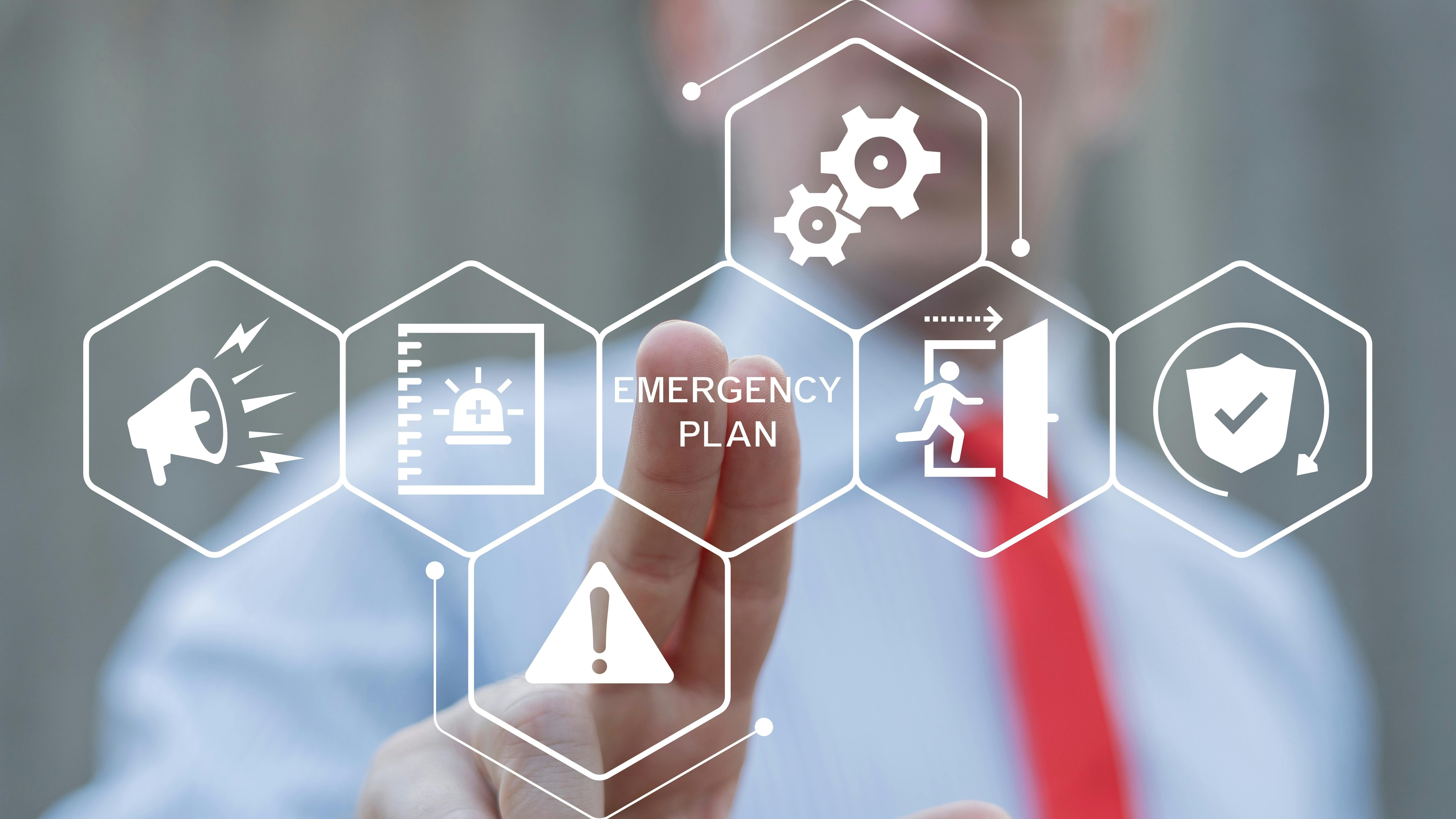 Business professional interacting with a digital emergency plan interface featuring icons for alerts, first aid, evacuation, safety procedures, equipment and hazard warnings