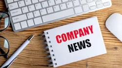 Notepad with text company news on a wooden desk with keyboard, mouse, pen and glasses .